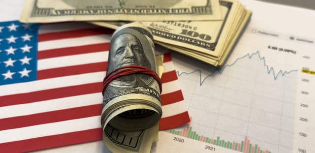 Bandeira dos Estados Unidos com notas de dólar dobradas.