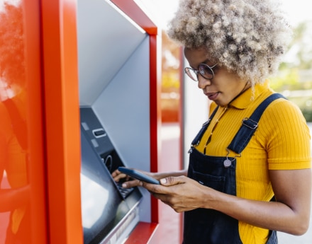 Mulher utilizando o caixa eletrônico