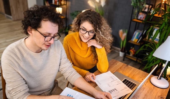 Casal analisando gráficos em um papel, juntos