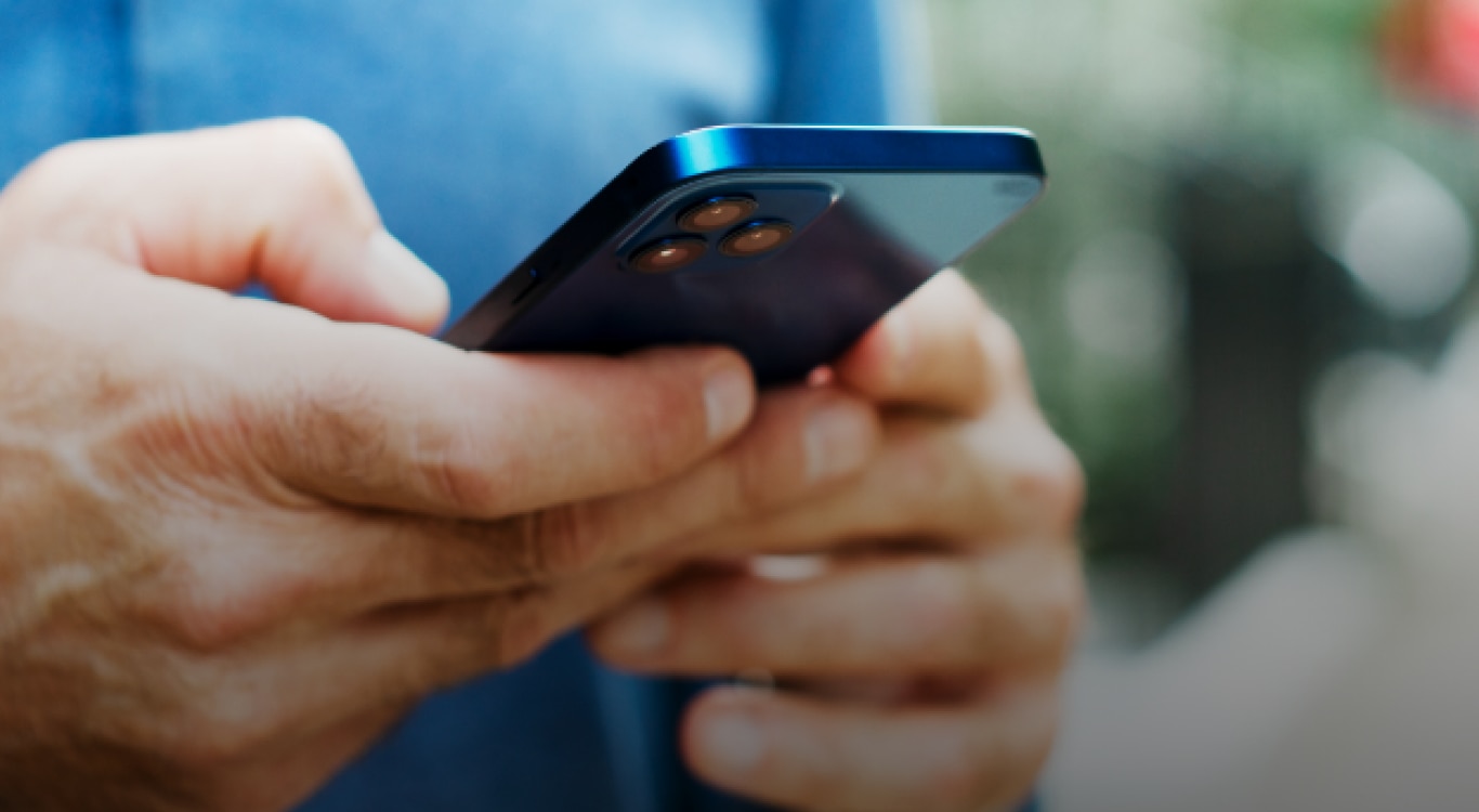 Homem segurando um celular pesquisando se é possível cancelar um pix