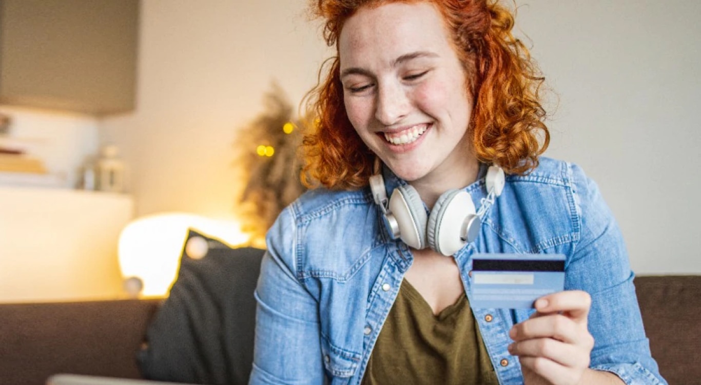 Mulher sorridente com cartão de crédito na mão