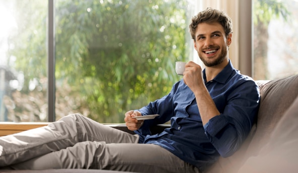 Homem de camisa azul tomando café