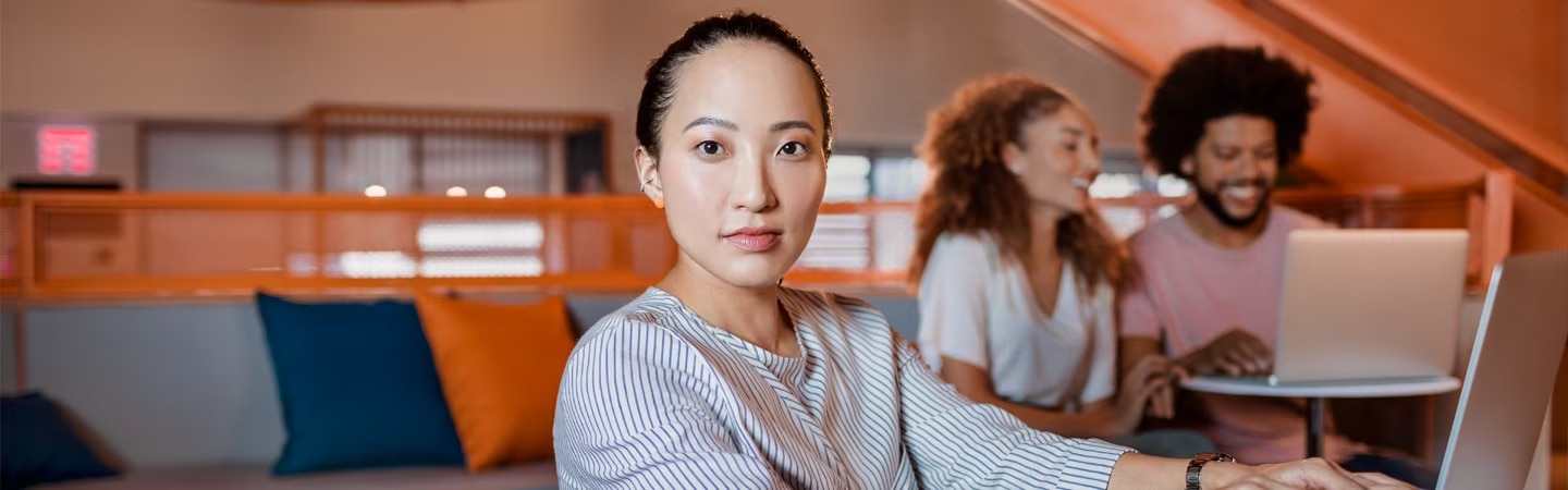 Mulher apoiada em uma mesa pesquisando no notebook quais os tipos de despesas o empreendedor digital precisa calcular