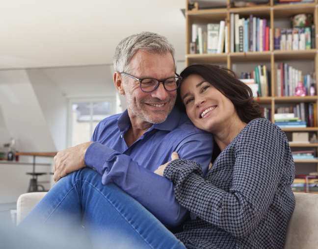 Casal de homem e mulher deitados na rede sorrindo.