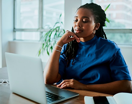 Mulher utilizando um notebook com atenção