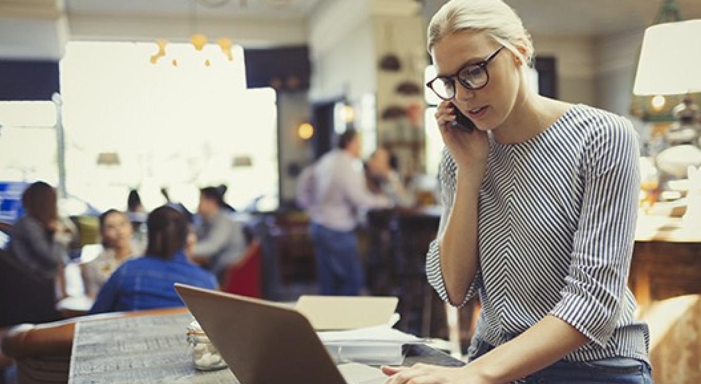 Mulher pesquisando em seu computador como superar as dívidas